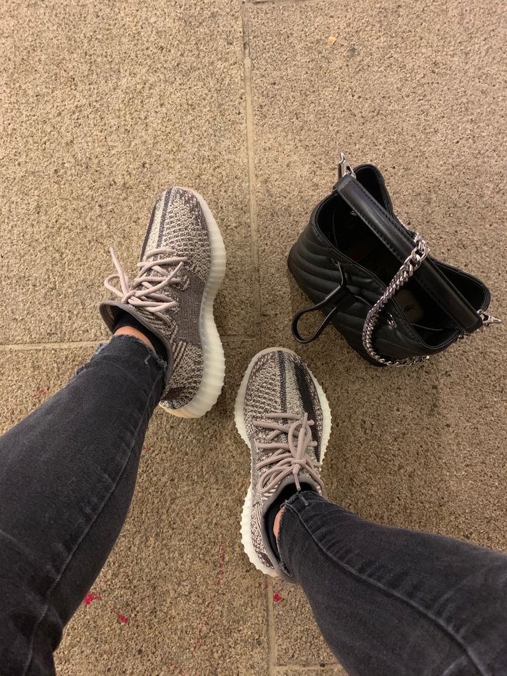 Adidas Yeezy Boost 350 V2 Zyon FZ1267 gedragen met donkere broek in een casual setting, gefotografeerd samen met een tas