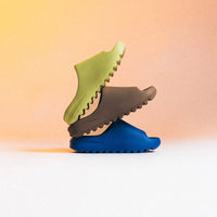 Meerdere Yeezy Slide Azure ID4132 paren in display – lined-up opstelling in felle azuurblauwe tint, zomerready look