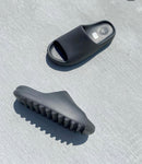 In-hand shot van Yeezy Slide Onyx HQ6448 – EVA body in matzwart, diepe zoolstructuur en Yeezy-logo binnenin zichtbaar