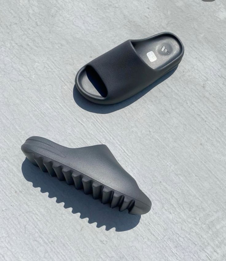 In-hand shot van Yeezy Slide Onyx HQ6448 – EVA body in matzwart, diepe zoolstructuur en Yeezy-logo binnenin zichtbaar