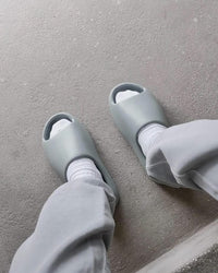 Yeezy Slide Salt aan voet met witte sokken – cleane zomervibe voor airport fits, festivals of loungewear