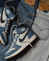 Jordan 1 Denim gedragen met een denim-on-denim fit – de ruwe denim panelen blenden stijlvol met een lichte spijkerbroek

