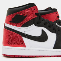 Close-up van de Nike Air-branding op de tong van de Jordan 1 Ruby – authentieke OG-look met klassieke rode tongpatch en gewatteerde afwerking