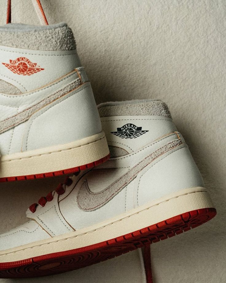 Hielaanzicht van twee gestapelde Rare Air Cinnabar sneakers – zicht op het gestikte Rare Air-logo en vintage off-white middenzool