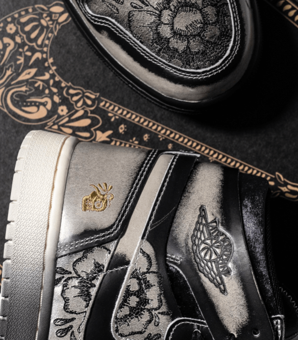 Close-up van de hiel met gouden embroidery en gegraveerde motieven op het bovenwerk – visuele hommage aan Día De Muertos-tradities in een modern silhouet