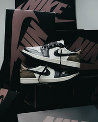 Air Jordan 1 Low OG Mocha (SKU CZ0790‑102) – in‑hand shot met zicht op witte midsole, zwarte outsole en Palomino nubuck hieloverlay