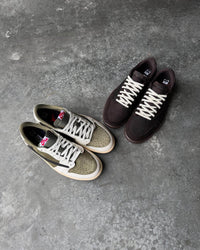 Detail van Air Jordan 1 Low OG Travis Scott Medium Olive (SKU DM7866‑200) met Cactus Jack tonglabel en Sail overlays