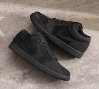 Air Jordan 1 Low SE Craft Dark Smoke Grey Varsity Red (SKU FD8635‑001) on‑foot met casual denim en speckled zwarte outsole zichtbaar