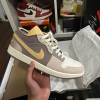 Air Jordan 1 Low SE Craft Inside Out (SKU DN1635‑100) – in‑hand shot met zicht op nubuck textuur, exposed tongue en tongue-tag
