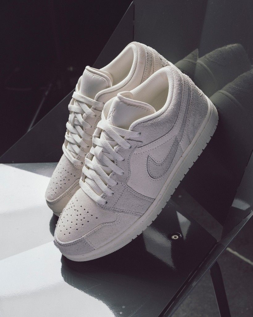 Detail van Air Jordan 1 Low SE Craft Pale Ivory (SKU FQ3055‑100) met zicht op textured suede panels en wings logo op hiel
