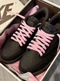 Air Jordan 1 Low OG Travis Scott Velvet Brown (SKU DM7866‑202) – in‑hand shot met zicht op reverse Swoosh, woven Nike Air tag en brown rubber outsole