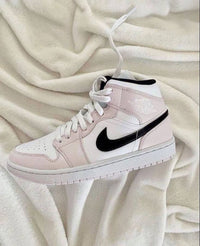 Air Jordan 1 Mid Barely Rose – close-up van lederen textuur, stiksels en roze veters, ideaal voor detailgerichte sneakerliefhebbers