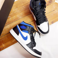 Uit de doos: Jordan 1 Mid Black Racer Blue – zwarte overlays, witte zool en Jumpman branding op tong in blauw zichtbaar