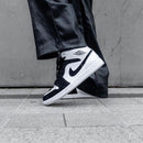 Meerdere Jordan 1 Mid Carbon Fiber sneakers op rij – glanzende afwerking onder studioverlichting, populaire keuze onder jongeren