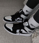 Jordan 1 Mid Carbon Fiber aan voet met zwarte cargobroek – glans in zonlicht, streetwear styling voor dagelijks gebruik