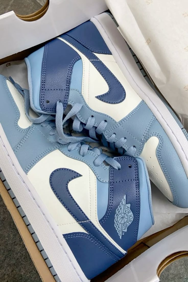 In-hand shot Jordan 1 Mid Diffused Blue – helder blauw leer, witte zool en lichtgrijze accenten zichtbaar onder natuurlijk licht