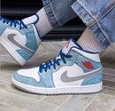 Uit de doos: Air Jordan 1 Mid French Blue – combinatie van suède en leer, met rode Jumpman en grijze kraag