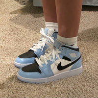 Close-up van lederen textuur rond toebox, Swoosh en hiel – ice blue leer gecombineerd met zwart stiksel en witte zoo