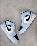 Jordan 1 Mid Ice Blue uit doos – witte lederen basis, ice blue panelen en zwarte Swoosh direct zichtbaar