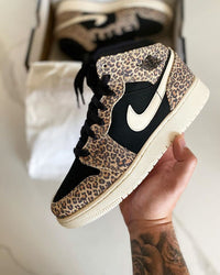 Close‑up Air Jordan 1 Mid SE GS Leopard – focus op luipaardprint suede, witte Swoosh en stitching; ideaal voor legit‑check visuals