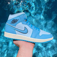 Uit de doos: Air Jordan 1 Mid Ice Blue – witte lederen basis, ijzig blauwe panelen en zwarte Swoosh zichtbaar