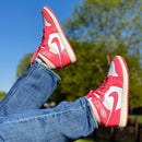 Jordan 1 Mid Strawberries and Cream aan voet met witte flared pants – pastel sneakerlook perfect voor lente en zomerfits