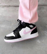 Close‑up van Air Jordan 1 Mid Light Arctic Pink – focus op het zilver-wings logo, stitching en roze outsole voor legit‑check visuals