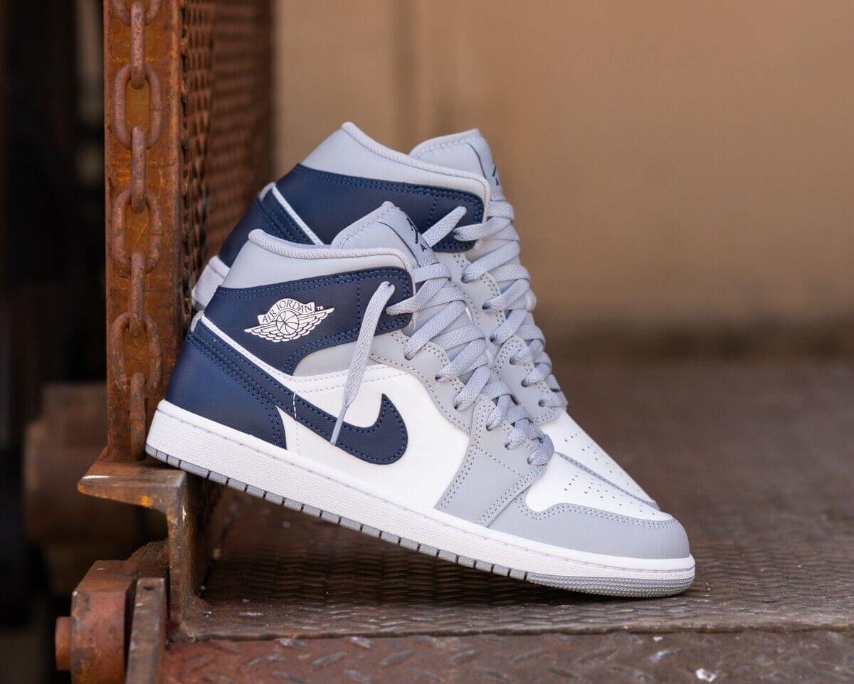 Close‑up Air Jordan 1 Mid Wolf Grey Midnight Navy – focus op navy Wings-logo, stitching en midsole detail; ideaal voor legit‑check visuals