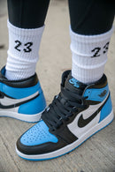 On feet look van de UNC Toe Jordan 1 gedragen met een washed jeans – de combinatie van university blue, zwart en wit valt clean en fris


