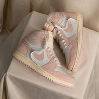 Jordan 1 Washed Pink on feet gecombineerd met beige of wit – de pasteltinten zorgen voor een elegante en frisse vibe

