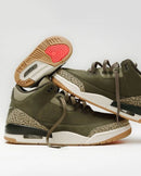 Close-up van de Air Jordan 3 Retro Family Affair DN3707-202 met zichtbare Air unit, Total Crimson binnenzool en olijfgroene premium afwerking.