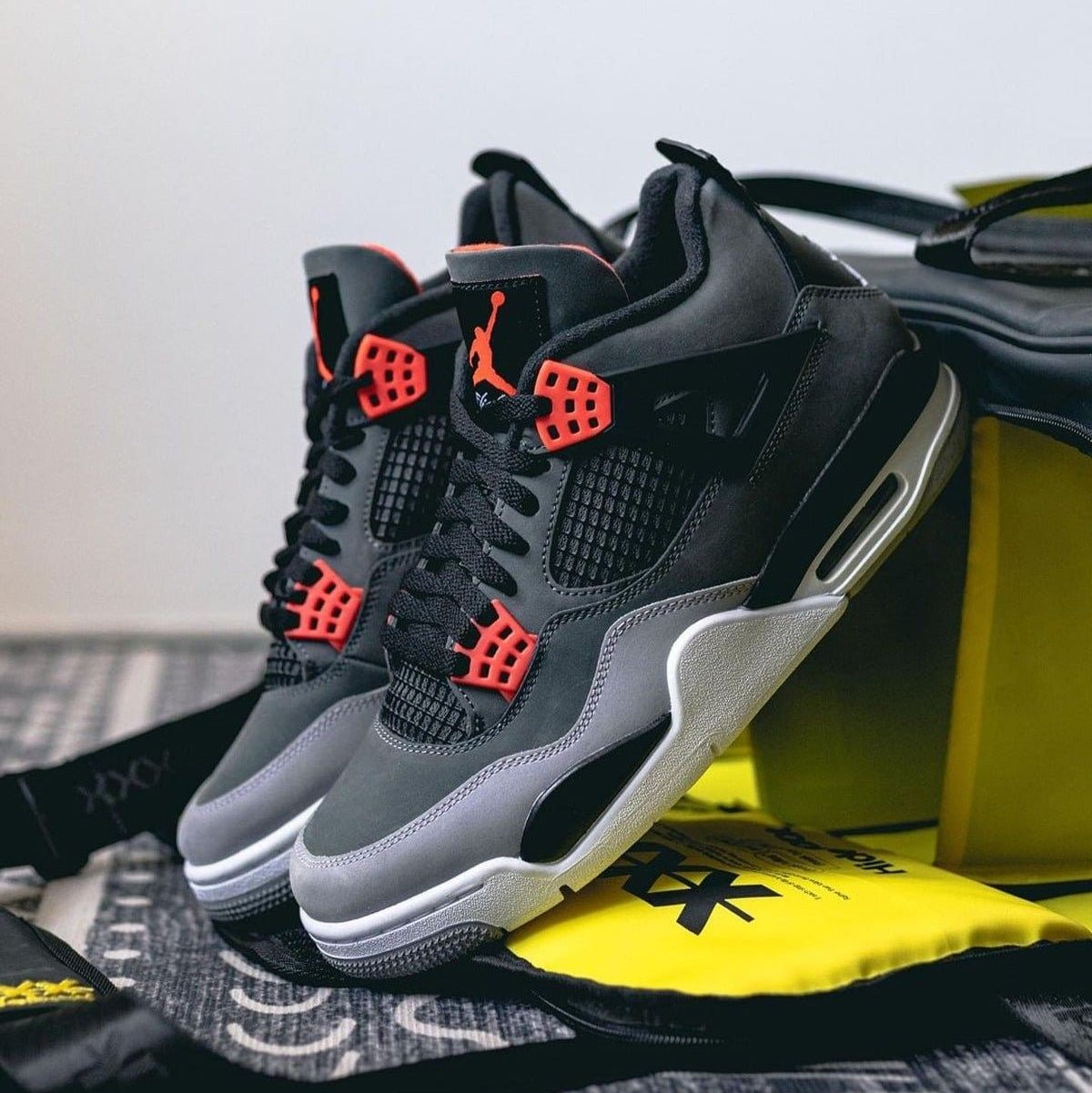 Originele verpakking van DH6927-061 opengeklapt met cementprint op het deksel en beide sneakers schuin geplaatst op het originele inpakpapier