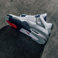 Close-up van DH6927-140 toont het Jumpman-logo op de tong, cementaccenten rond de zool en diep navy cages tegen wit leer