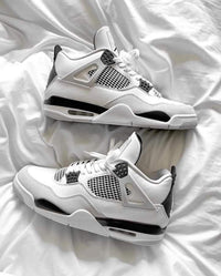 DH6927-111 half uit de cementdoos geschoven, met zicht op het Jumpman-logo, witte tongstructuur en zwarte branding tegen zachte ondergrond