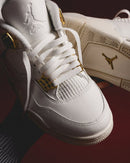 Close-up van de gouden eyelets en witte nubuck basis, premium materialen en luxe afwerking zichtbaar.