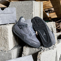 FQ7928-001 half uit de Paris 2024-box geschoven, met zicht op de zilvergrijze suede upper, unieke hielclip en transparante zoolstructuur