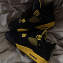 Originele Thunder-box van DH6927-017 geopend met cementprint-deksel en beide sneakers diagonaal geplaatst op vouwpapier