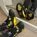 Air Jordan 4 Thunder 2023 DH6927-017 gedragen met losvallende jeans, zichtbaar in beweging met felgele middenzool en zwarte cages