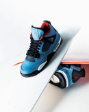 Detailshot van 308497-406 toont het gestikte rode Jumpman-logo, zwarte meshpanelen en de grove textuur van het blauwe suède