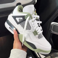 Air Jordan 4 Seafoam AQ9129-103 in hand vastgehouden bij de hiel, met zicht op mintgroene heeltab, witte lederen upper en zachte binnenzijde