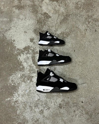 Meerdere paren FQ8138-001 strak gestyled op matzwarte ondergrond, met white-on-black colorblocking en zichtbare tonglabels in beeld