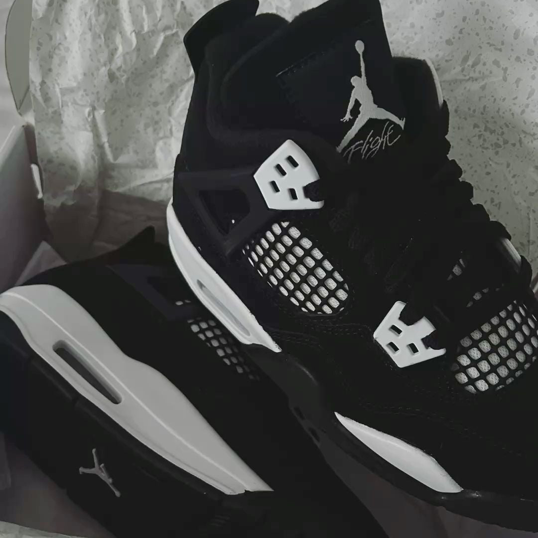 Jordan 4 White Thunder FQ8138-001 gedragen met zwarte cargos en witte sokken, gefotografeerd tijdens lopen met scherpe focus op het silhouet