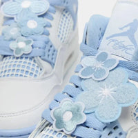 Air Jordan 4 WMNS Forget Me Not sneaker met pastelblauwe bloemaccenten en Oil Green details close-up