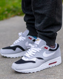 Hielshot van de Nike AM1 Urawa met gestikte Japanse branding en zichtbare kleurblokken in zwart, grijs en rood