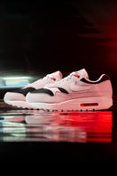 In-hand shot van de Nike Air Max 1 Urawa met contrasterende kleuren, zichtbare Air-unit en retro club-inspired design