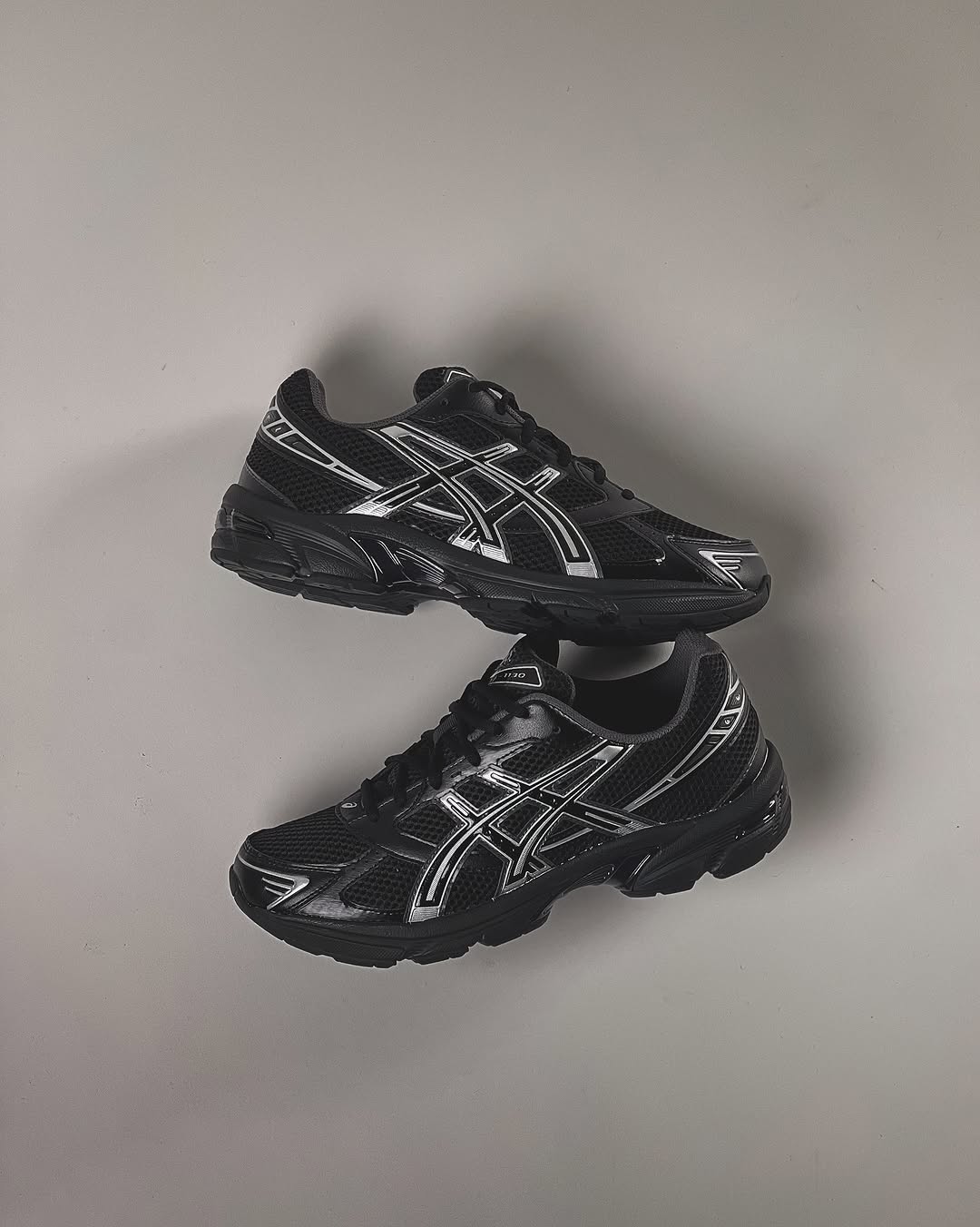 Close-up van de ASICS GEL-1130 Black Pure Silver 1201A256-020 met GEL-demping, zwarte meshstructuur en metallic tiger stripes

