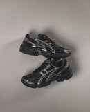 Close-up van de ASICS GEL-1130 Black Pure Silver 1201A256-020 met GEL-demping, zwarte meshstructuur en metallic tiger stripes

