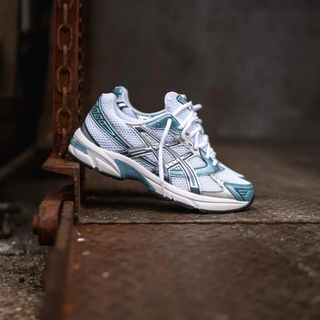 ASICS GEL-1130 Shark Tank 1201A256-116 in hand met dark grey colorblocking, glanzende accenten en lichtgewicht retro-ontwerp

