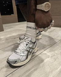 ASICS GEL-1130 White Black 1201A256-101 in hand met ademend mesh, contrasterende zwarte tiger stripes en GEL-constructie

