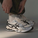 ASICS Gel Kayano 14 Cream Black Plum vastgehouden in hand met zicht op hielstructuur en retro branding, SKU 1202A056 118

